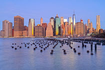 Wooden Poles und Skyline von Downtown Manhattan bei Dämmerung by Rainer Grosskopf