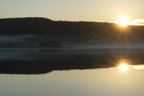 The setting sun is reflected in a glassy forest lake von Intensivelight Panorama-Edition