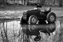 Toy tractor reflected in rain puddle black and white picture by Maud de Vries