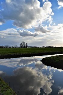 Clouds reflected in water in Dutch polder landscape by Maud de Vries
