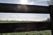 Dutch landscape silhouette seen trough a wooden fence by Maud de Vries