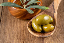 Grüne Oliven auf einem Holzlöffel - Green olives on a wooden cooking spoon von Thomas Klee