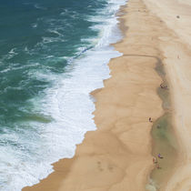 View on beach and ocean with waves from above, at lighthouse Nazaré in Portugal von Bastian Linder