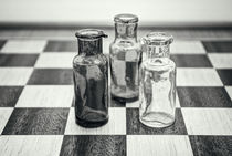 Drei Flaschen im Gespräch auf einem Schachbrett by ullrichg