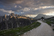 Mountain landscape in the European Dolomite Alps underneath the Three Peaks with chapel and footpath during sunset, South Tyrol Italy by Bastian Linder