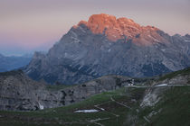 Mountain landscape in the European Dolomite Alps underneath the Three Peaks with alpenglow and chapel during sunrise, South Tyrol Italy von Bastian Linder