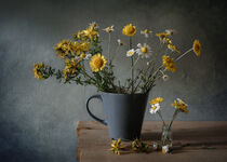 Chamomile flowers in a cup and in a vial