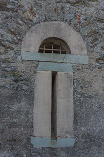 a slit  with security grating of an ancient castle by susanna mattioda
