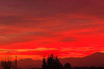 a spectacular sunset over the mountains paints the sky of pink by susanna mattioda