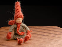 Handmade crochet autumn Gnome, with red hat and scarf, sitting position by Valentijn van der Hammen
