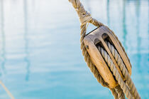 Pulley with ropes of a classic sailing boat and blue sea water von Alex Winter