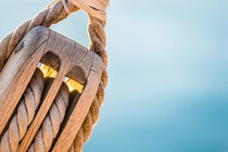 Nautical pulley with ropes of a classic sailing boat and blue sea water by Alex Winter