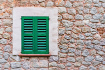 Green closed window shutters and rustic stone wall von Alex Winter