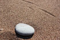 weißer Stein auf glattgespültem Sand