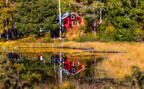 red Swedish house near a lake on a sunny autumn day