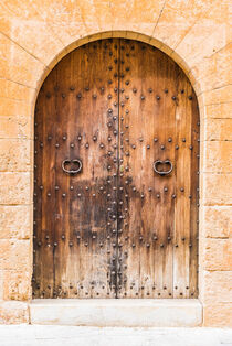 Old rustic brown wooden front door of a mediterranean house, closeup von Alex Winter