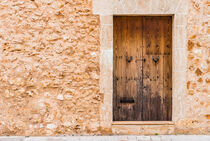 Mediterranean house stone wall with old wooden door, detail view by Alex Winter
