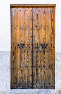 Brown old wooden front door house entrance of mediterranean house von Alex Winter