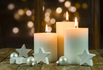 Three Advent and Christmas candles with decoration and sparkling light background by Alex Winter