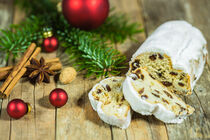 Christmas time, baked Christmas stollen cake with pieces on wooden table with traditional decoration by Alex Winter