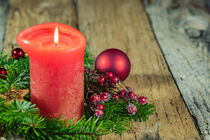 Advent and Christmas time decoration, red candle with green fir branches wreath and ornaments on wooden table by Alex Winter