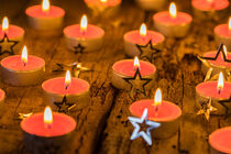 Traditional Advent and Christmas candles with silver star shapes decoration on wooden table by Alex Winter
