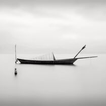 Boat resting on lagoon water by Kostas Pavlis
