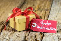 Weihnachtsgeschenk mit roter Schleife und Weihnachtsgrüße Frohe Weihnachten by Alex Winter