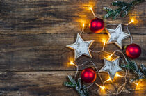 Xmas decoration with christmas ornaments and light on wood background by Alex Winter