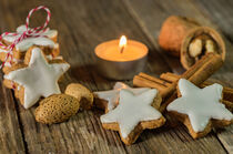 Weihnachtsplätzchen Zimtsterne mit Teelicht auf Holztisch by Alex Winter