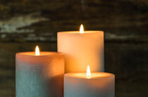 Three burning candle flames at night von Alex Winter