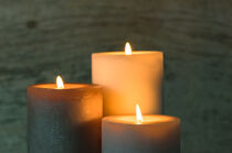 Three burning candles in the dark by Alex Winter