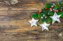 Weihnachtsdeko mit Sternen, Tannenzweig und roten Beeren auf Holzhintergrund by Alex Winter