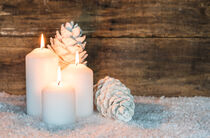 Drei weiße Kerzen für Advent oder Weihnachten mit Tannenzapfen im Schnee by Alex Winter