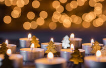 Christmas or Advent candles with golden xmas trees decoration and blurred lights in the background by Alex Winter