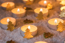 Christmas or Advent candlelights with golden xmas trees decoration on snow by Alex Winter