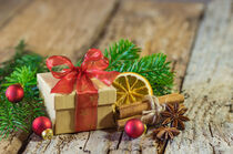 Weihnachtsgeschenk mit roter Schleife und Weihnachtsdeko by Alex Winter