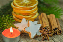Christmas decoration with star cookies, spices, orange slices and candlelight von Alex Winter