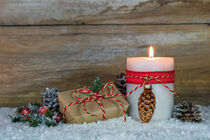 Adventskerze oder Weihnachtskerze mit Weihnachtsgeschenk im Schnee von Alex Winter