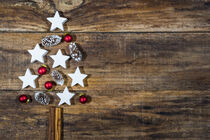 Xmas tree decoration with white stars, pine cones and red christmas balls on wood by Alex Winter
