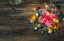 Weihnachtsgeschenk mit Weihnachtsdekoration und Lichtern auf Holz Hintergrund by Alex Winter