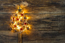 Christmas tree with red and golden christmas balls and lights on wood von Alex Winter