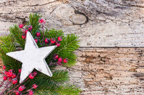 Weihnachtsdekoration mit weißem Stern, roten Beeren und Tannengrün auf Holz von Alex Winter