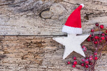Christmas star with Santa Claus cap and red berries on wood von Alex Winter