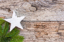 Weihnachtsdekoration mit weißem Stern und Tannenzweig auf rustikalem Holz von Alex Winter