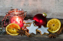 Weihnachtsdekoration mit Kerze, Zimtsternen, Orangenscheiben und weihnachtlichen Gewürzen von Alex Winter