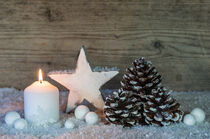 White candle with christmas decoration with snow, pine cones and ornaments  by Alex Winter