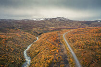 River and road through mountains with yellow trees in autumn along the scenic Wilderness Road in Lapland in Sweden from above von Bastian Linder
