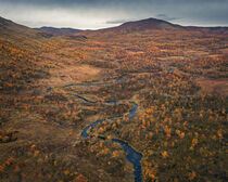 River through mountains with yellow trees in autumn along the scenic Wilderness Road in Lapland in Sweden from above by Bastian Linder