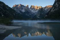 Alpenglow of Lake Lago di Landro at Toblach with mountain chain mirroring on water surface during sunrise by Bastian Linder